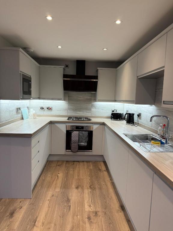 cocina grande con armarios blancos y suelo de madera en Luxury townhouse in Stirling, en Stirling