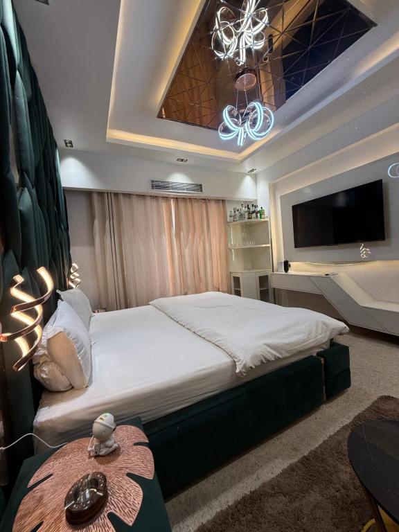 Un dormitorio con una cama grande y un televisor. en Omaxe Hazratganj Studios, en Lucknow