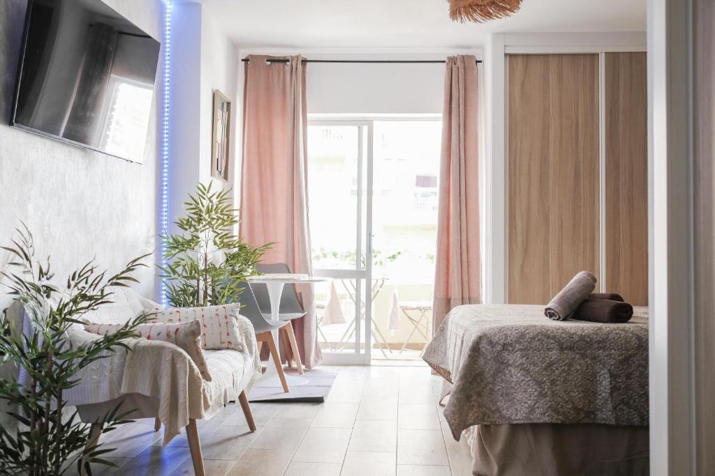 Un dormitorio con una cama y una mesa y una ventana. en Apartament Magic Home Iris Reception 24h, en Benalmádena
