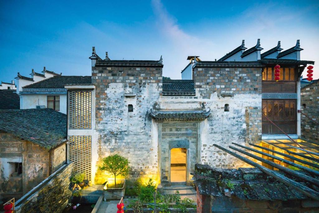 an old stone building with a gate in the middle at Wuyuan Jiwei Mountain Lodge (Sixi-Yan Village Scenic Area) in Wuyuan