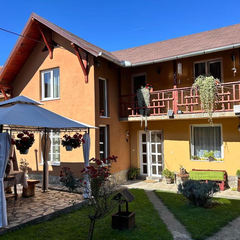 a house with an umbrella and a patio at La Teo in Măru