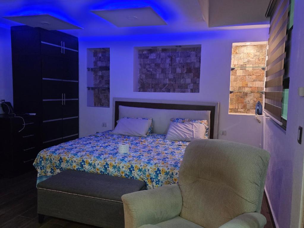 ein Schlafzimmer mit einem Bett und einem Stuhl und violetten Lichtern in der Unterkunft Casa, Habitación, Alojamiento, Estancia- in Chiapa de Corzo