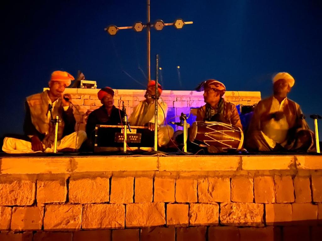 a group of men sitting on a brick wall at Taj heritage camp& resort in Jaisalmer