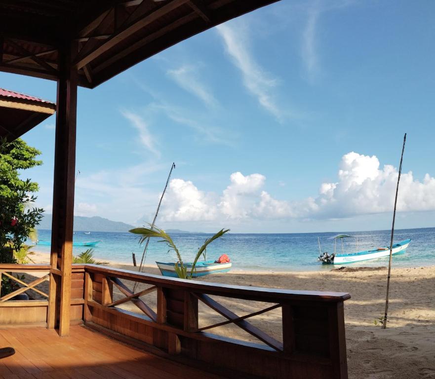 een uitzicht op een strand met een boot in het water bij Pantai Naama Bungalow 