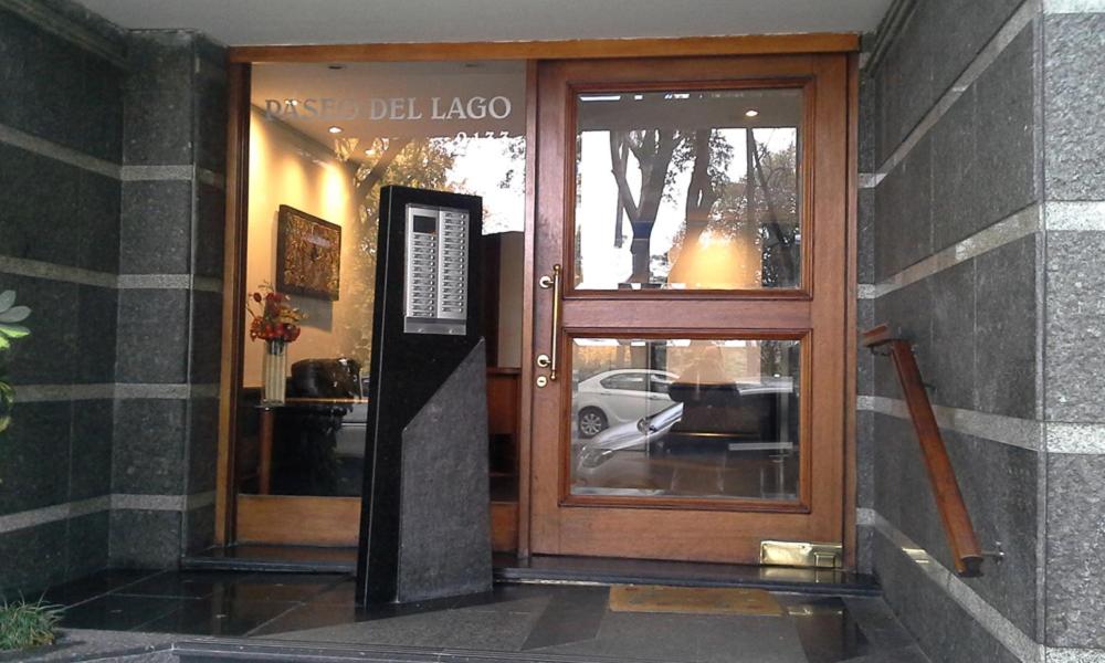 Una puerta a una tienda con un cartel. en Apartamento Paseo del Lago, en Montevideo