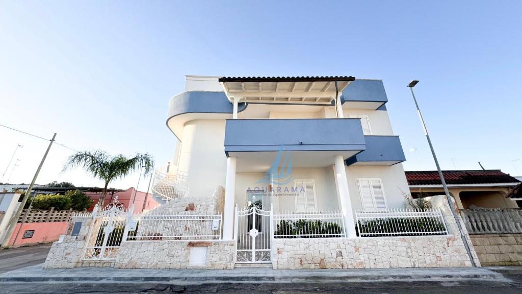 a white building with a blue roof at AQUARAMA Rooms & Apartments in Torre Squillace