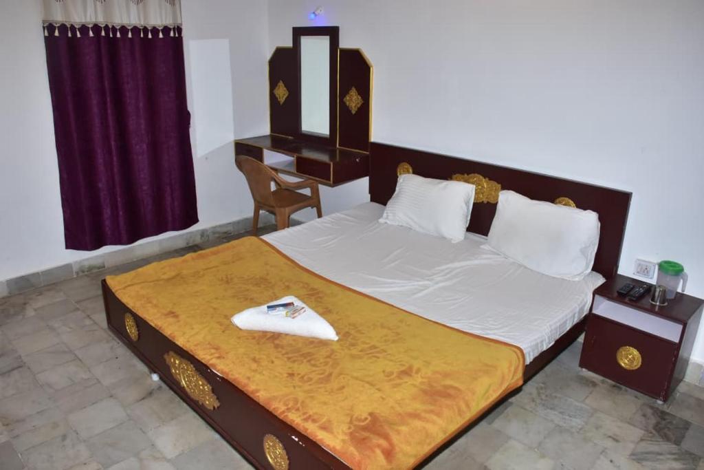 a bedroom with a large bed with a desk at Mookambigai Residency in Kodaikānāl