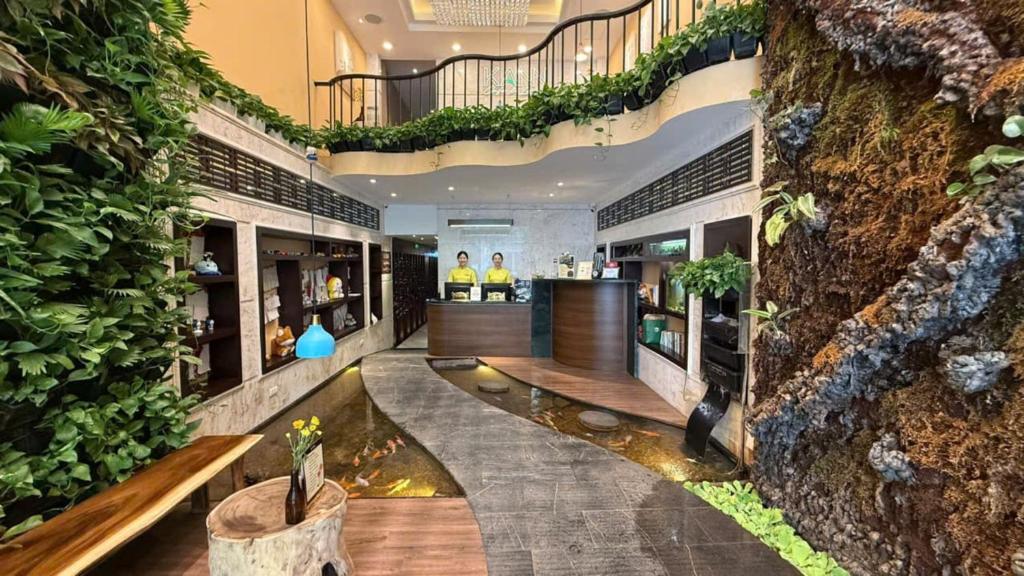 a hotel lobby with a bar and plants at Hanoi Brilliant Hotel & Spa in Hanoi