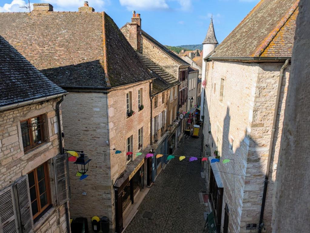 an alley in an old town with flags and buildings at Gîte des Siècles - Maison du XIVe siècle avec Ascenseur et Cinéma in Saint-Gengoux-le-National