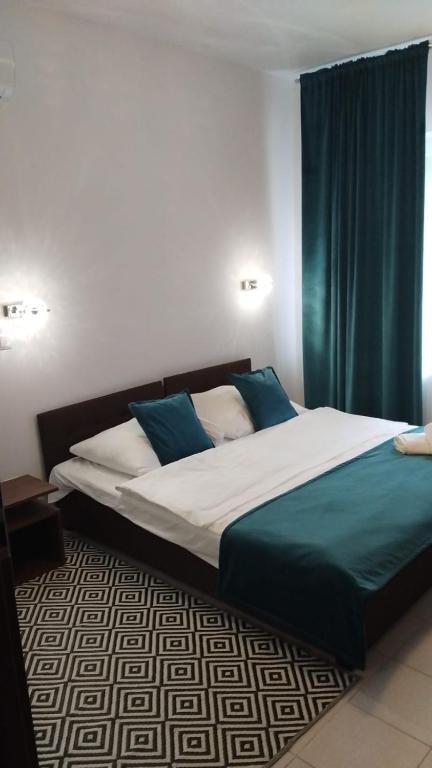 a bedroom with a large bed with blue curtains at Perła Dalików in Dalików