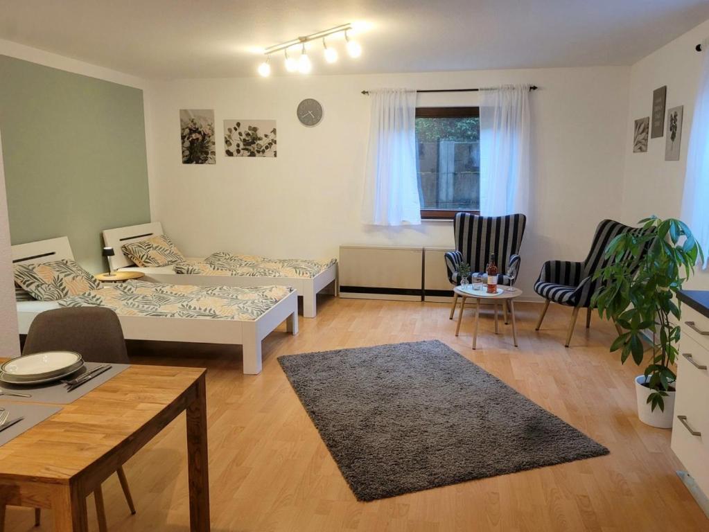 una sala de estar con dos camas y una mesa en Work & Stay Holidayflat, en Kusterdingen