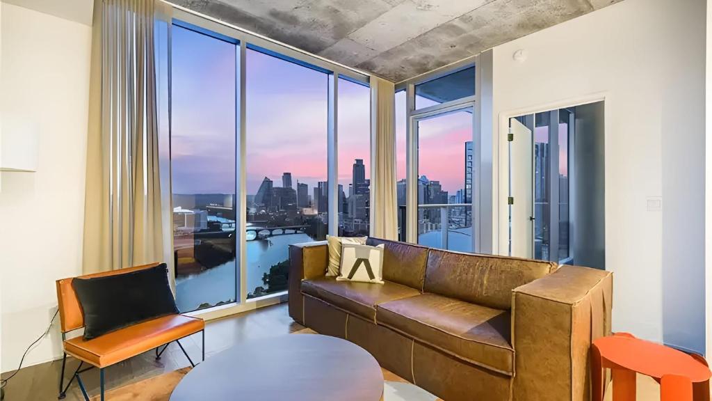 a living room with a couch and a large window at 2 Luxury Condos 1 Block from Rainey St New High Rise w Rooftop Pool Gym in Austin