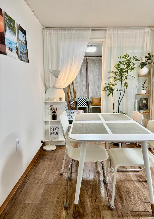 a dining room with a white table and chairs at 루나스테이 in Seoul