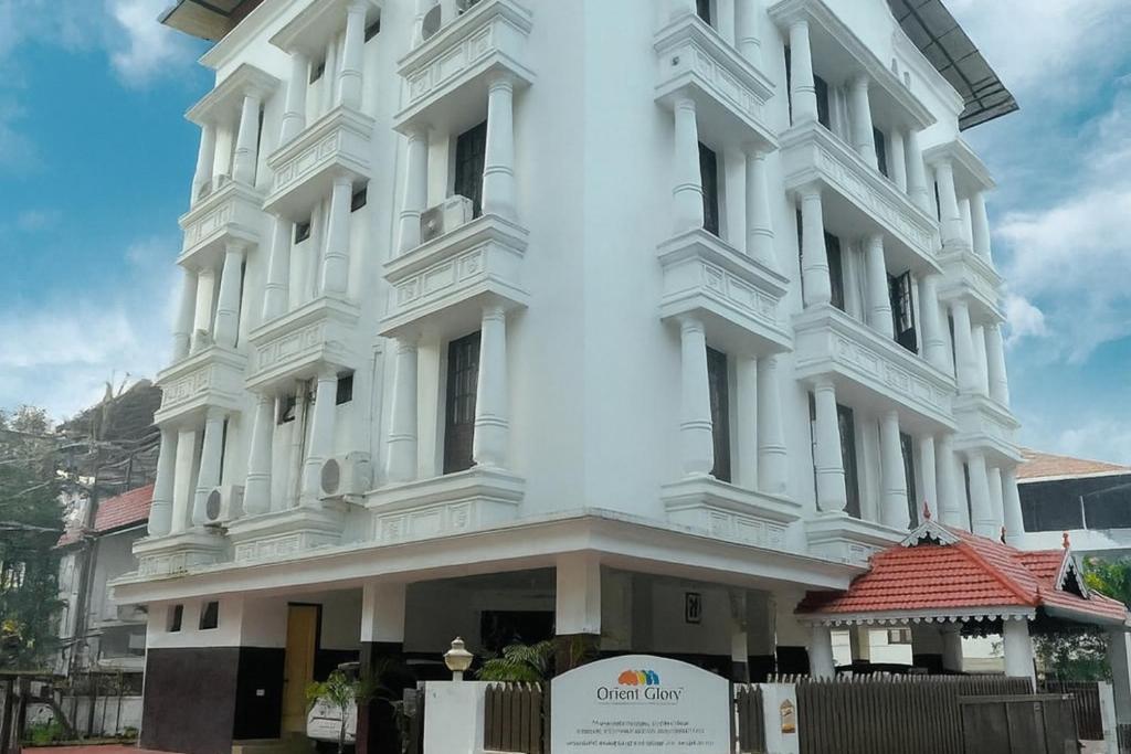 a white building with a sign in front of it at Orient Glory - Walk to Lulumall & Metro in Edappally