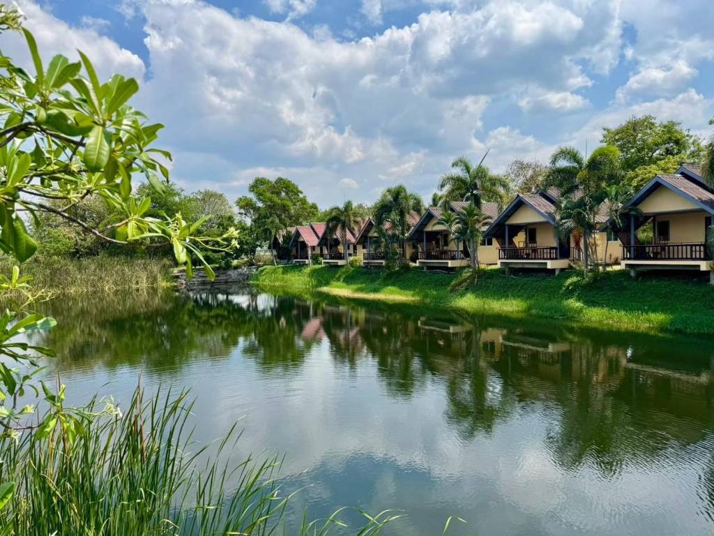 eine Reihe von Cottages neben einem Fluss in der Unterkunft Khao Yai Lake Hill Resort in Khanong Phra
