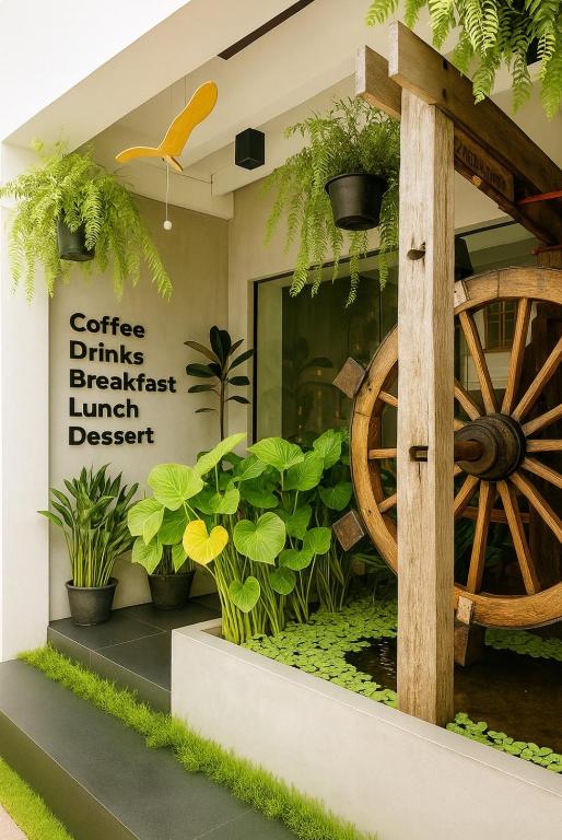 a store front with a wooden wagon wheel and plants at Beanstay hostel in Phuket
