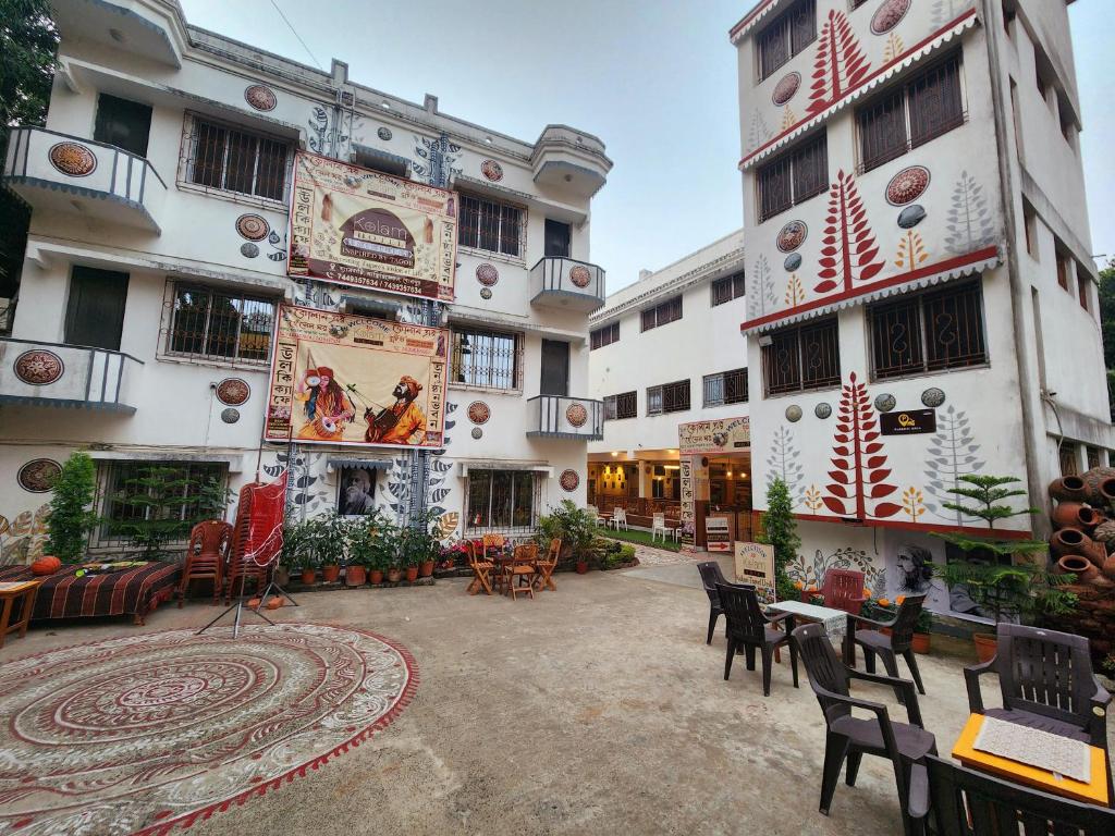 a courtyard of a building with chairs and tables at Hotel Kolam in Shānti Niketan