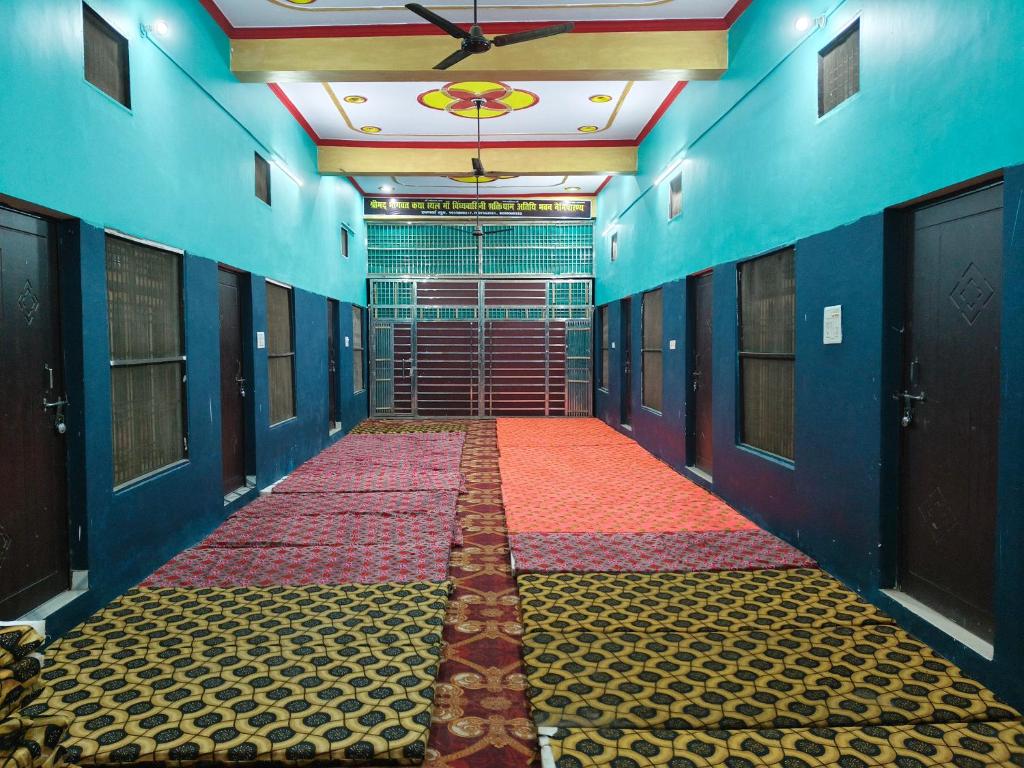 NaimishāranyaMa vindhyavasini Atithi Bhavan的一条空荡荡的走廊，墙壁是蓝色的，铺着一块红地毯。