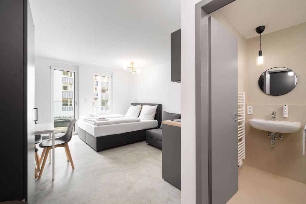 a room with a bed and a sink and a couch at Homaris Apartments Therese in Munich