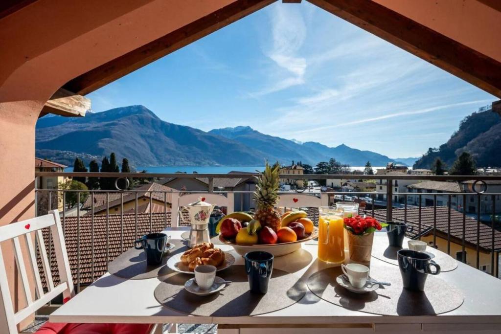 - une table avec un bol de fruits sur un balcon avec vue dans l'établissement Art Music House Lake Como Beach 5 minutes walk, à Dongo