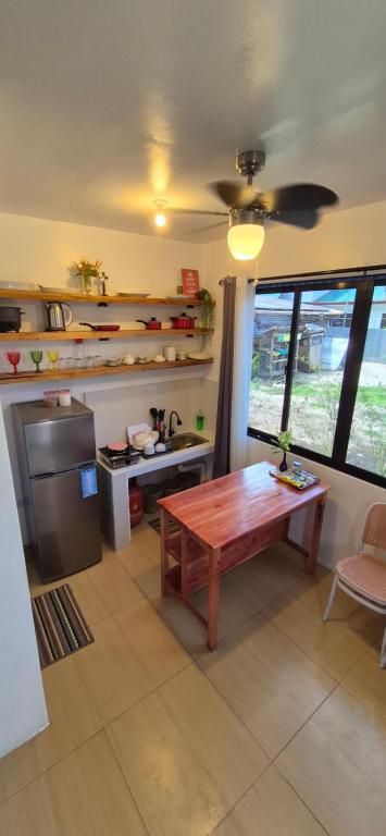 cocina con mesa de madera y cocina con fogones en GBoy Guest House, en General Luna