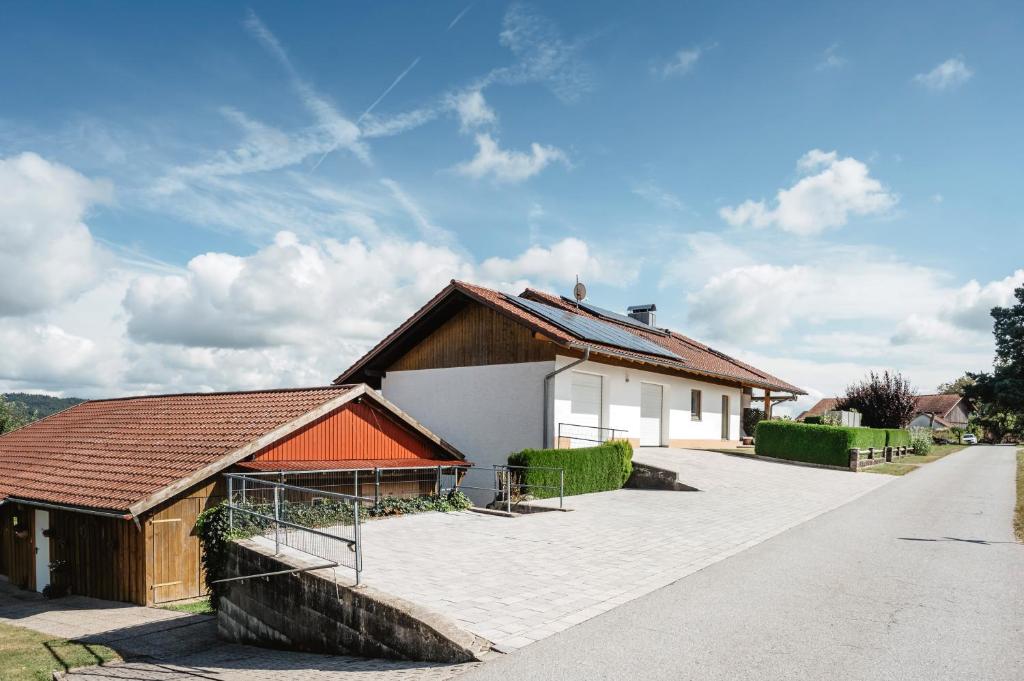 a white house with an orange roof on a driveway at Ferienhaus zur Weinlaube in Thurmansbang