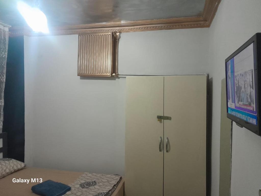 a room with a refrigerator and a flat screen tv at Langa Esra in Istanbul