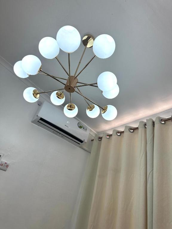 a chandelier hanging from a ceiling with a shower curtain at Stay with Recxy 1 in Dar es Salaam
