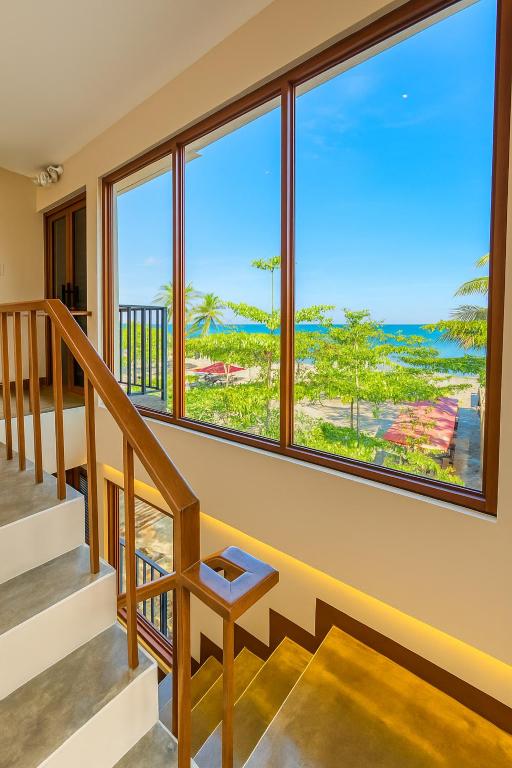 a room with a staircase and a large window at Kāpena Siargao in General Luna