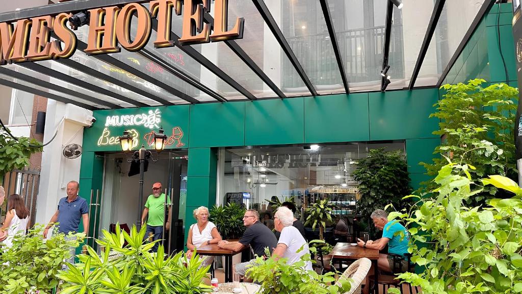 a group of people sitting at tables outside of a restaurant at Times Hotel at Bassac Lane in Phnom Penh