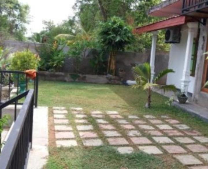 a backyard of a house with a garden and a fence at Elephant View Hotel in Damana