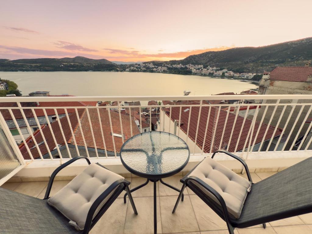 a balcony with a table and chairs and a view of the water at Delmare Lake view house in Kastoria