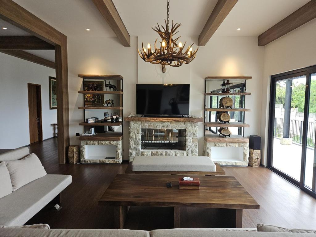 un salon avec un canapé et une cheminée dans l'établissement Villa Pine Hill Coolibah, à Gegarbensang