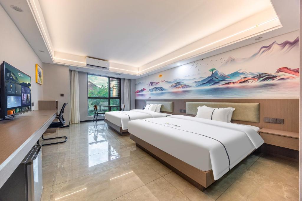 a hotel room with two beds and a flat screen tv at Haier International Hotel Vientiane Wattay Airport Branch offers free airport pick-up and drop-off upon prior reservation. in Vientiane
