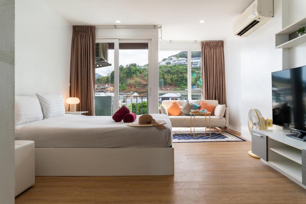 a bedroom with a bed and a living room at 1 BR Suite 8-198 at Ozone Condo near Kata beach and surf in Kata Beach