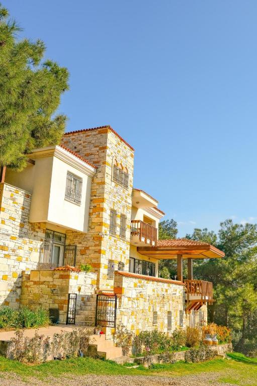 a large stone building with a deck on it at Rida Sultan Konağı Kozbeyli in Eskiömerler