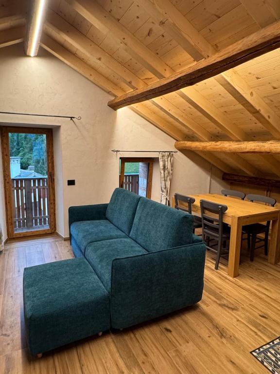 a living room with a blue couch and a table at Caluma El Paradis in Comune Rivamonte Agordino