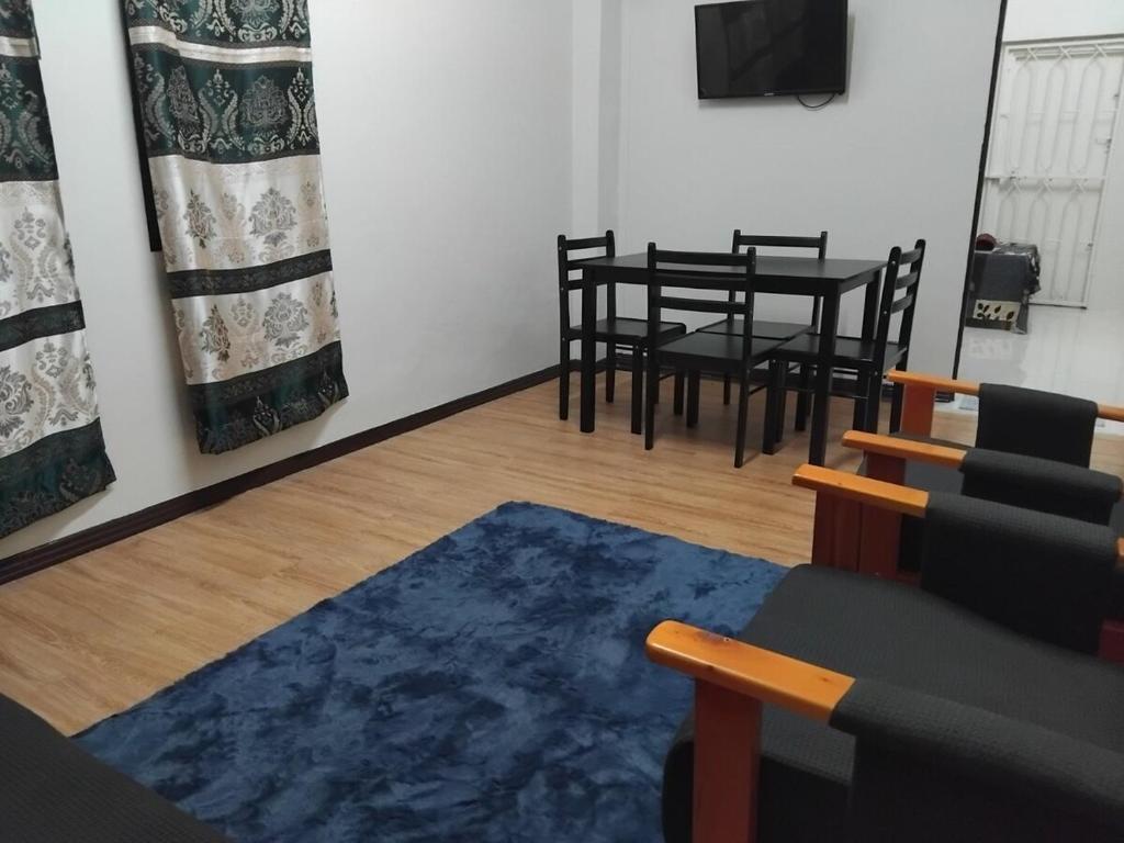 a living room with a table and chairs and a blue rug at Toorak Suva 2BR City Center Minutes Away in Suva