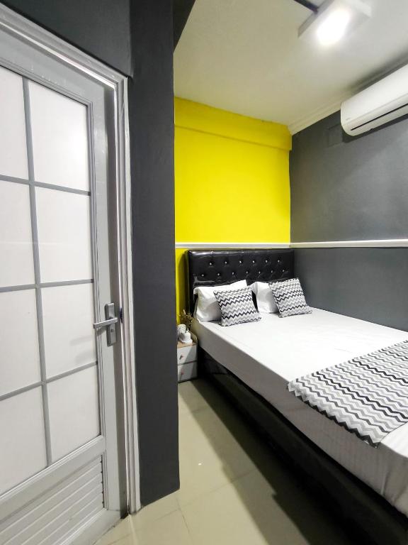 a bedroom with a bed and a yellow wall at Alap Stay-Inn in Candi