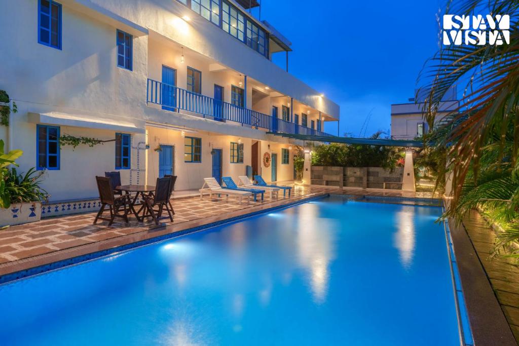 una villa con piscina por la noche en StayVista at Thalassa Near The Beach, en Alibaug