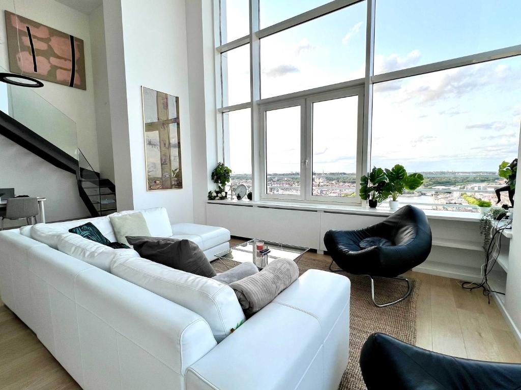 a living room with a white couch and two chairs at Skyline Penthouse Brussels 220 m2 of Pure Luxury Suite in Brussels