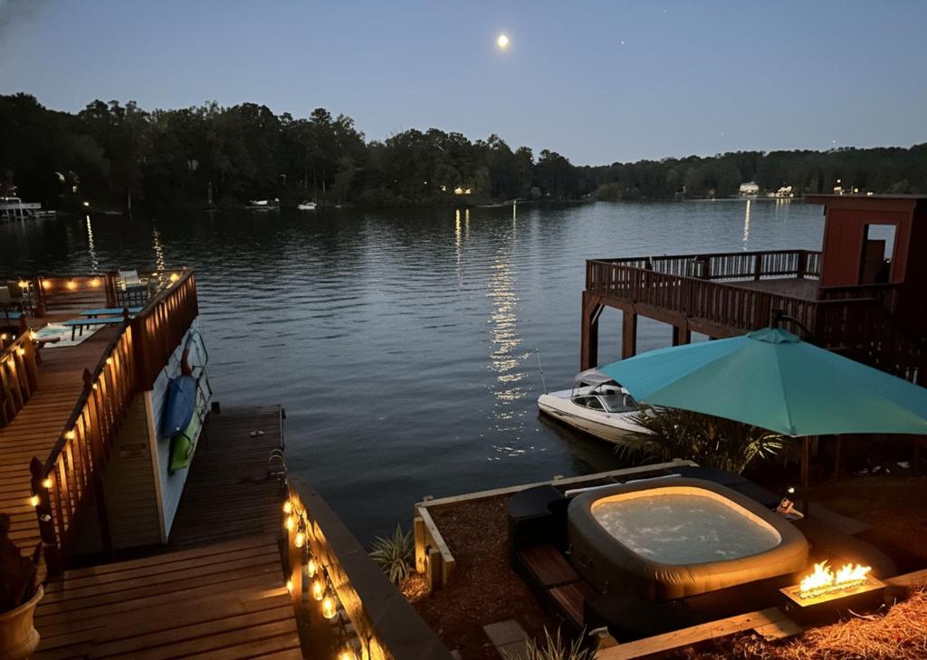 a boat is docked at a dock with an umbrella at Lakefront Escape with Sauna Hot Tub BBQ & Games in Norris Lake Shores