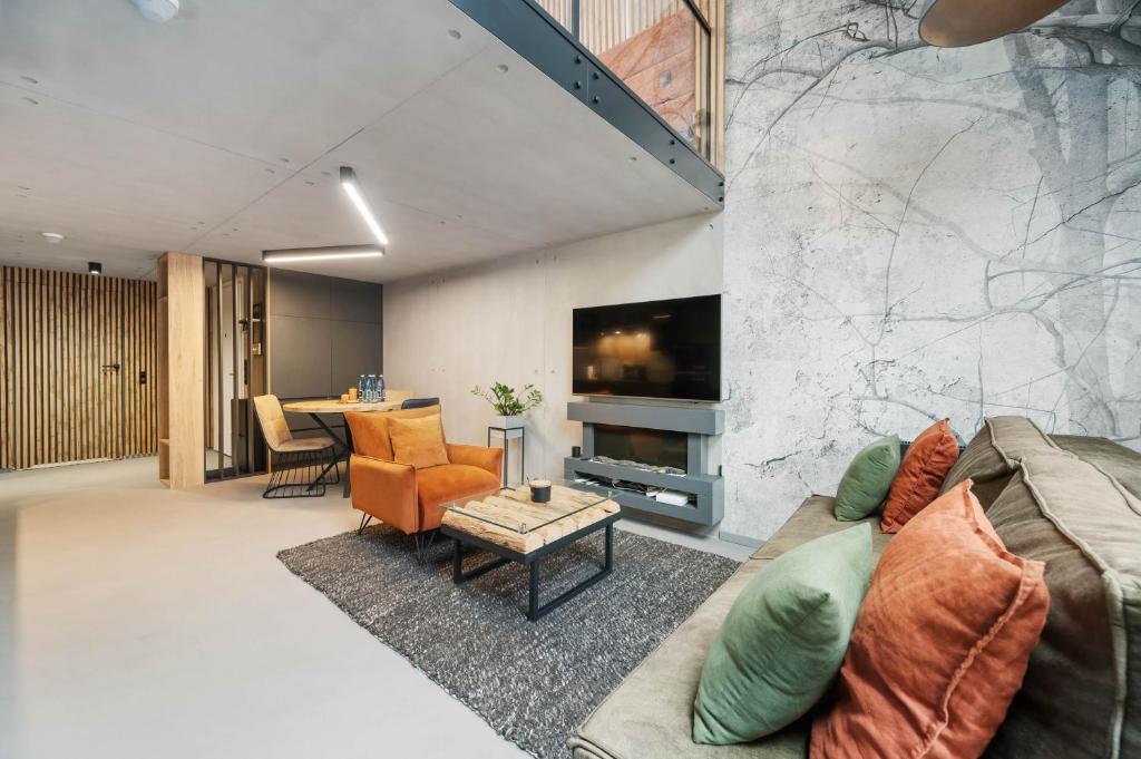 a living room with a couch and a tv at Calm Sauna & Jacuzzi by OneApartments in Sopot