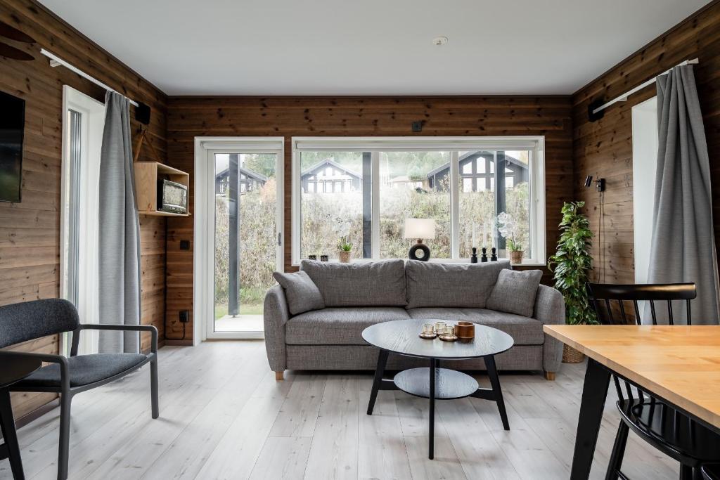 a living room with a couch and a table at Bergsgården Lodge Järvsö - Ski In Ski Out med bastu invid Järvsöbacken - OBS!!! BYTESDAGAR ÄR ENDAST TORS O SÖND OBS!!! in Järvsö