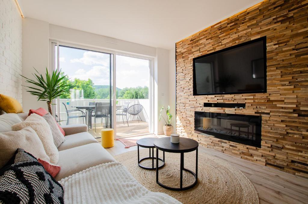 sala de estar con sofá y TV en una pared de ladrillo en Cosy house, 5 bedrooms, en La Celle-sous-Gouzon