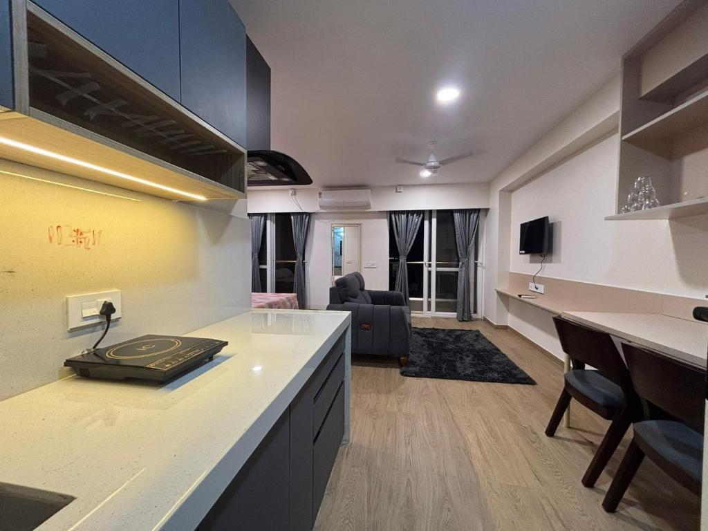 a kitchen with a counter and a living room at Aura Living in Pune