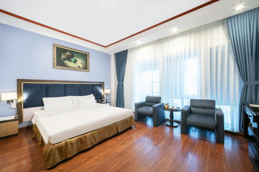 a hotel room with a bed and two chairs at A25 Hotel - 61 Lương Ngọc Quyến in Hanoi
