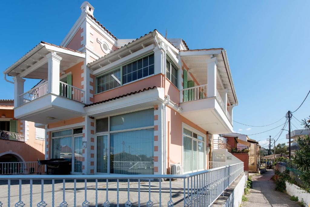 a large house with a fence in front of it at Kassiopi Home in Kassiopi