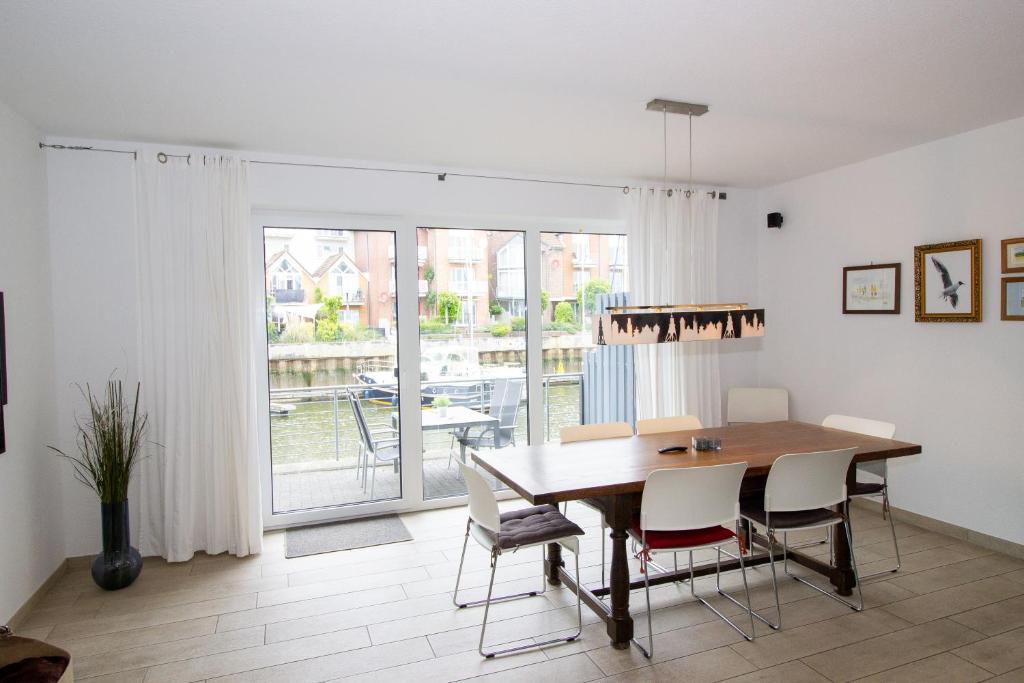 a dining room with a wooden table and chairs at Marina 24-A in Cuxhaven