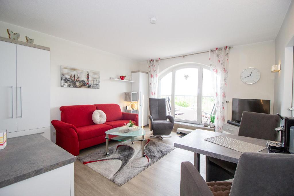 a living room with a red couch and a table at Deichgraf 345 in Döse